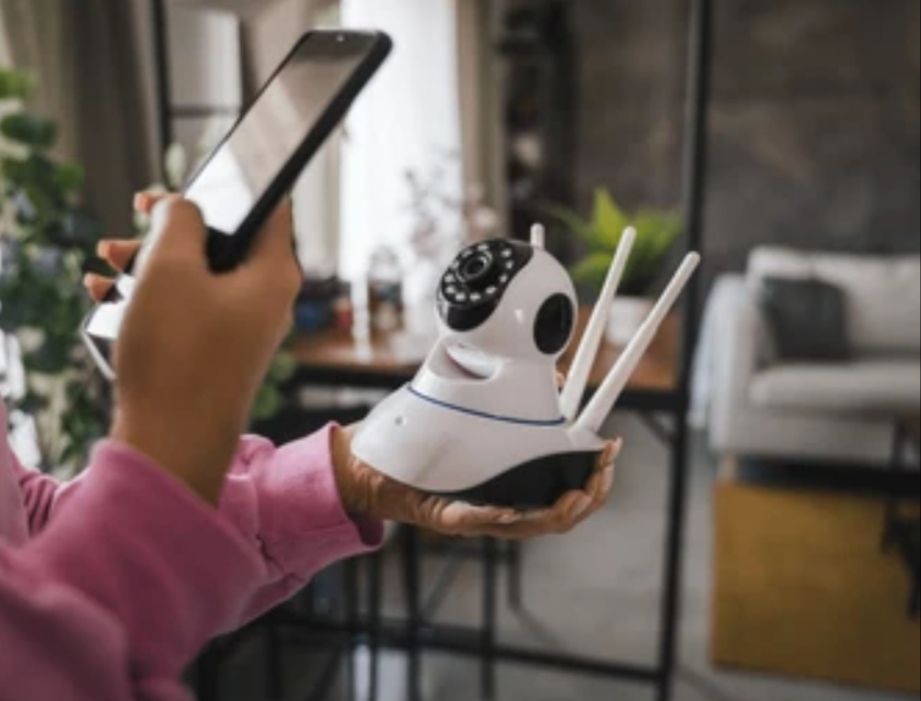 A person trying to connect smart security camera to the smart phones in his living room.