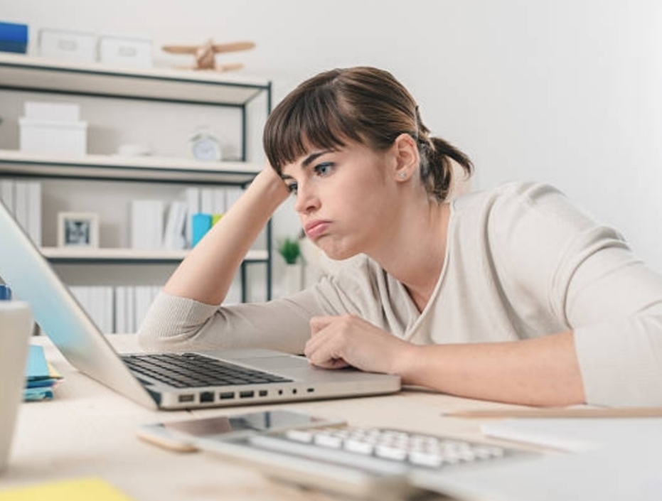 How to Speed Up a Slow Computer - A woman getting bored waiting for a slow computer to load.