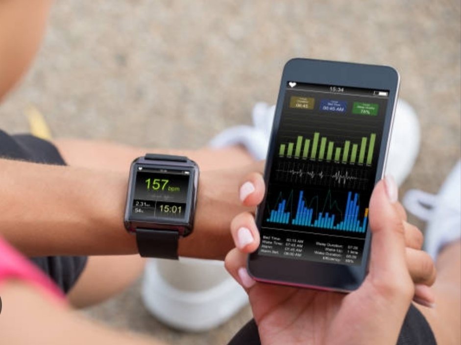 best fitness tracker for 2025- a guy wearing a fitness tracker on her left hand while using the phones on the other hand.