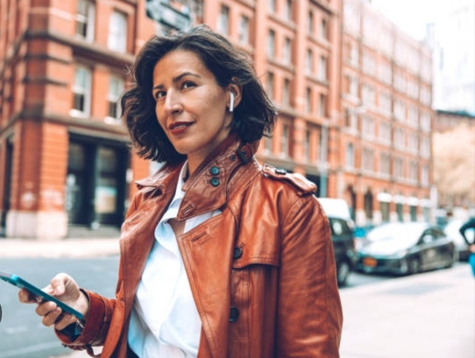 best wireless earbuds - a woman with her earbuds while walking on the street.