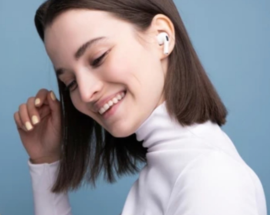 best wireless earbuds - a woman in white clothing with his earbuds smiling