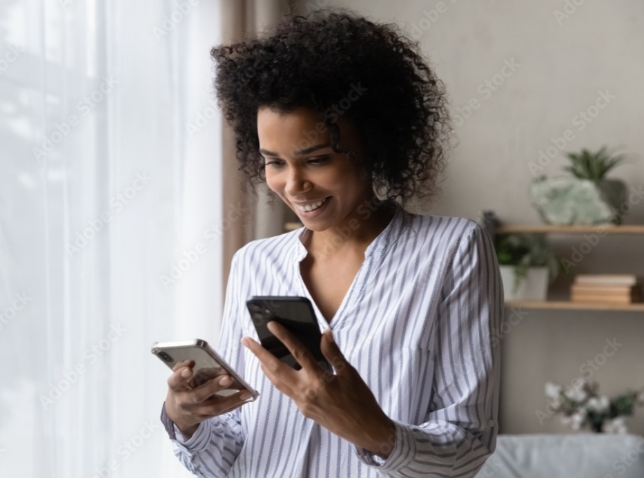 how to transfer data to a new phone - a woman wearing a white shirt holding two phones.